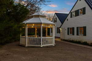 Back house at dusk with a gazebo