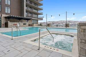 View of swimming pool featuring a mountain view and a hot tub