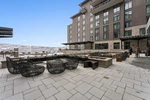 Snow covered patio featuring a fire pit and a mountain view