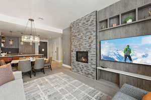 Living room with light wood-type flooring and a stone fireplace