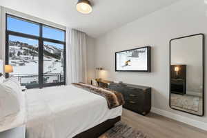 Bedroom with hardwood / wood-style floors, a mountain view, and multiple windows