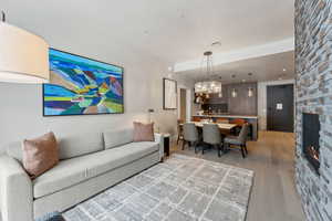 Living room with light hardwood / wood-style floors, a fireplace, and a chandelier