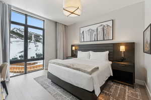 Bedroom featuring a mountain view, hardwood / wood-style floors, and expansive windows