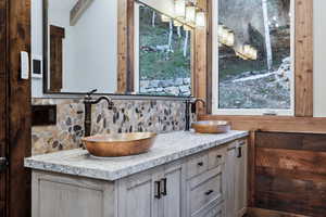 Bathroom with vanity, beam ceiling, and backsplash