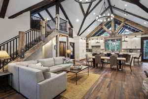 Living room with hardwood / wood-style flooring, a notable chandelier, and beam ceiling