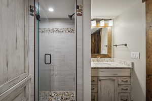 Bathroom featuring vanity and a shower with door