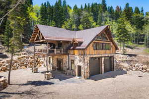 Log-style house with a deck and a garage