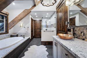 Bathroom featuring a chandelier, vanity, and separate shower and tub