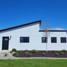 View of side of property with a lawn