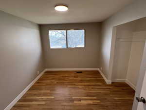 Unfurnished bedroom with a closet and wood-type flooring