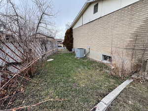 View of property exterior featuring central AC and a yard