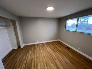 Unfurnished bedroom featuring wood-type flooring and a closet