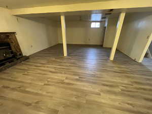 Basement with a fireplace and hardwood / wood-style flooring