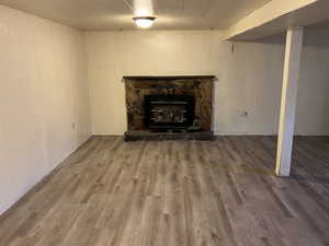 Unfurnished living room with a wood stove and hardwood / wood-style floors