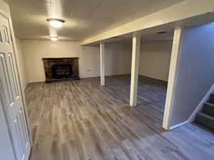 Basement with a fireplace and hardwood / wood-style floors