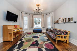 Living room featuring a chandelier, a textured ceiling, and dark hardwood / wood-style floors