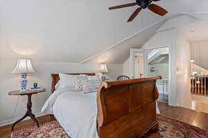 Bedroom with hardwood / wood-style flooring, ceiling fan, and lofted ceiling