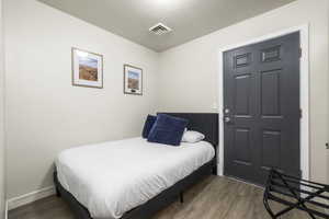 Bedroom with a textured ceiling and dark wood-type flooring