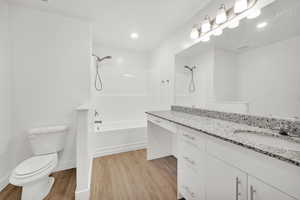 Full bathroom featuring hardwood / wood-style flooring, vanity, toilet, and shower / bathing tub combination