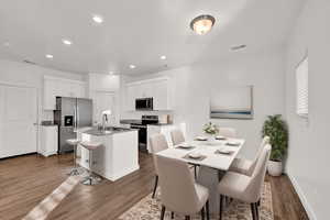 Digitally Staged Dining space featuring dark hardwood / wood-style floors and sink