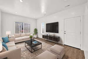 Digitally Staged Living room featuring hardwood / wood-style flooring