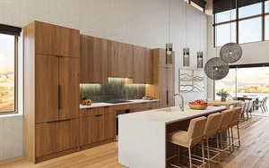 Kitchen featuring a center island with sink, black electric cooktop, sink, and light hardwood / wood-style flooring