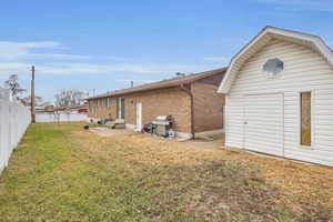 Back of house featuring a storage shed and a yard