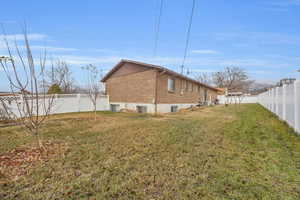 View of side of property featuring a yard