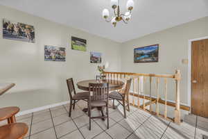 Dining room with a notable chandelier and light tile patterned floors