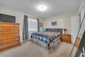 Carpeted bedroom featuring a textured ceiling