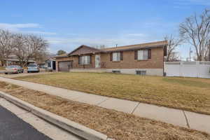 View of front of property featuring a garage and a front lawn