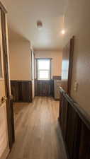 Corridor with light hardwood / wood-style floors and a textured ceiling