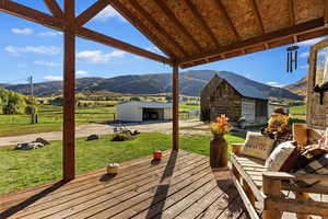 Deck featuring an outbuilding, a mountain view, and a rural view