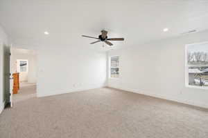 Owner's suite with ceiling fan and large windows.