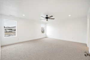 Owner's suite with ceiling fan and large windows.