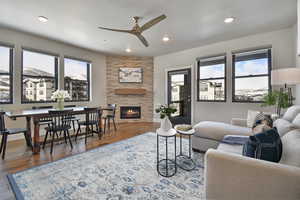 Living room with hardwood / wood-style flooring, ceiling fan, and a tile fireplace