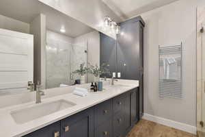 VIRTUALLY STAGED - Bathroom with hardwood / wood-style floors, vanity, and a shower with shower door