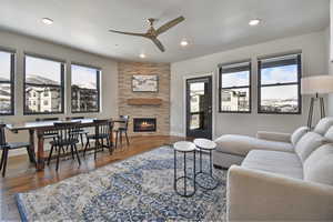 Living room featuring a tile fireplace, dark hardwood / wood-style flooring, and ceiling fan