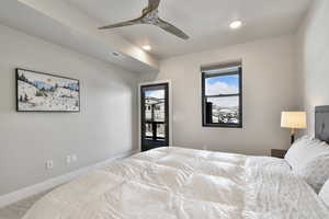 Carpeted bedroom featuring ceiling fan