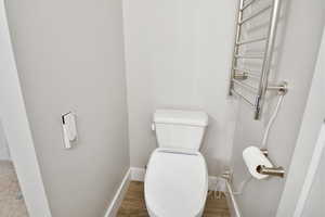 Bathroom with hardwood / wood-style flooring and toilet