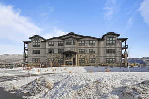 Snow covered rear of property featuring a mountain view