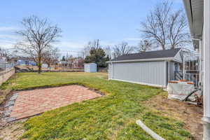 View of yard featuring a storage shed and a patio area