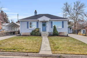 Bungalow-style home featuring a front yard and a carport