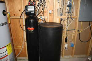 Utility room featuring water softener and electric panel