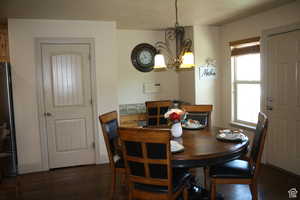 Dining space featuring dark hardwood / wood-style flooring and a notable chandelier