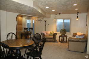 Carpeted dining area featuring a textured ceiling