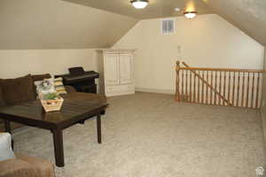 Interior space featuring lofted ceiling and light carpet