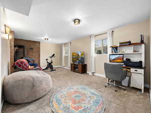 Carpeted office space/family room with a wood stove