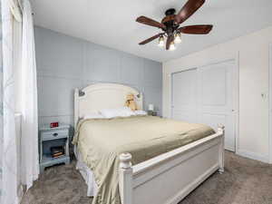 Bedroom featuring ceiling fan, a closet, and carpet floors