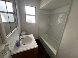 Full bathroom with tile patterned flooring, vanity, shower / bathtub combination, and toilet